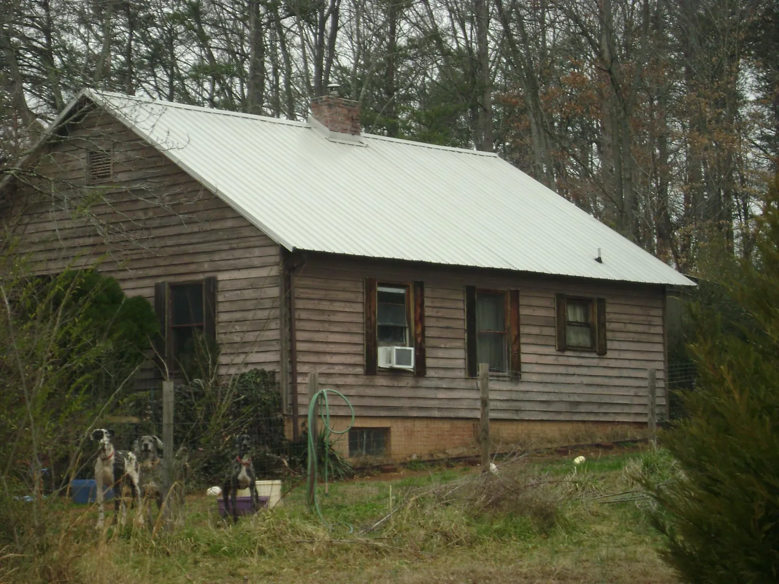 White metal roof on an old wood sided farmhouse, from a Metal Roof Installation job in Ione